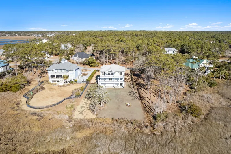 Aerial view of the raised custom beach house set in the coastal marsh near the waterway in Southport, NC
