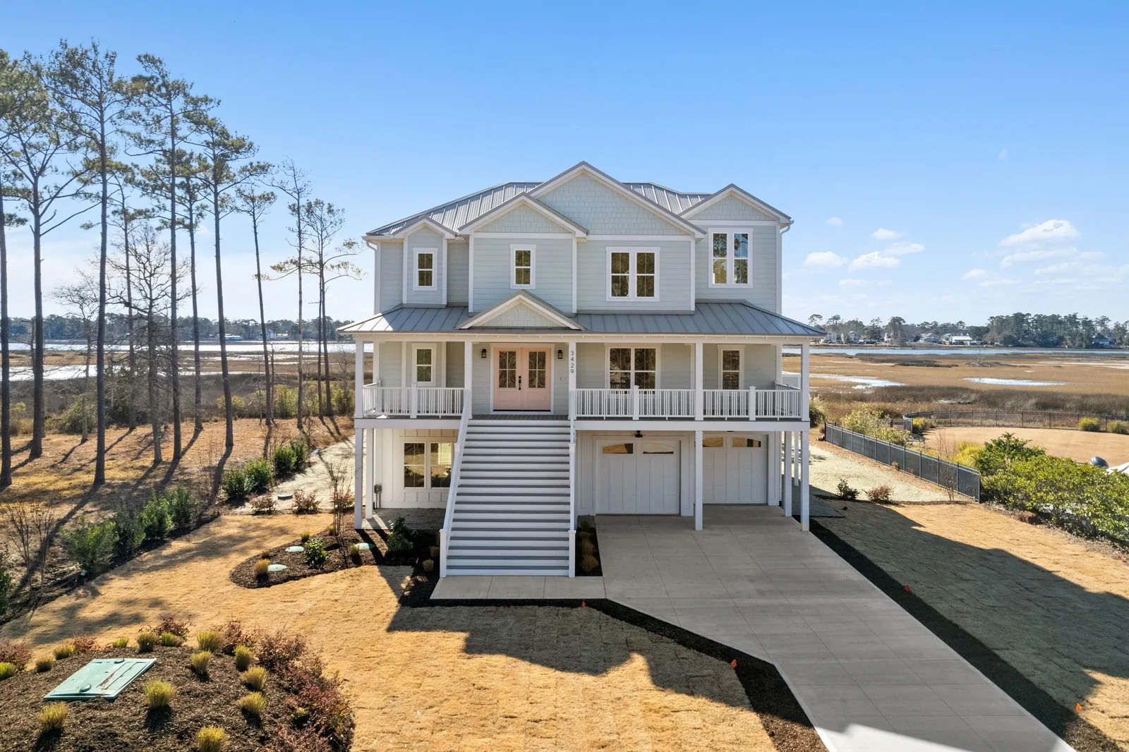 Front elevation of the flagship custom beach house at 3429 Scupper Run, a raised coastal home in Southport, NC by Northstar Custom Works