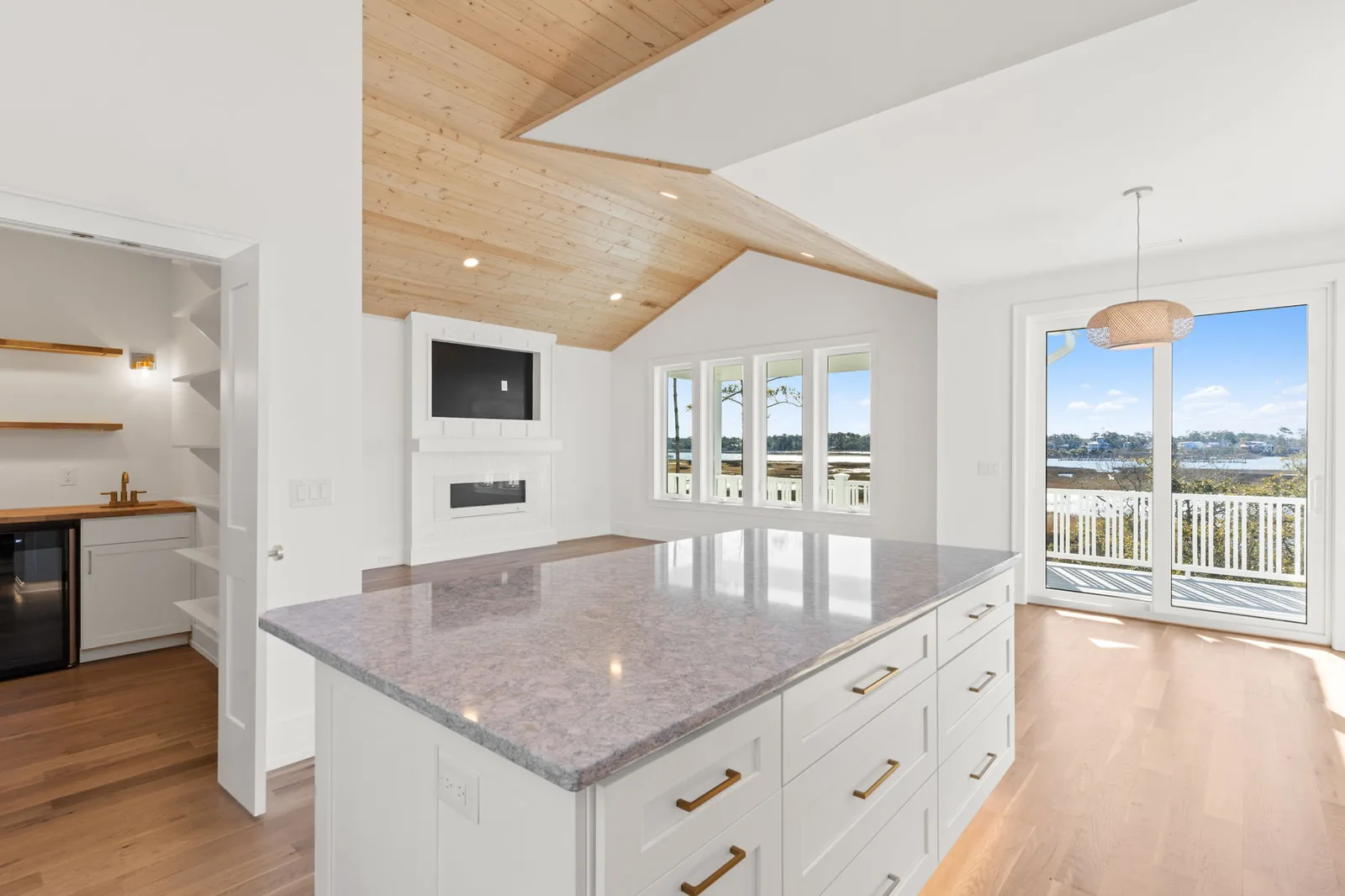 Vaulted living room with exposed wood beams in a custom coastal home in Southport, NC